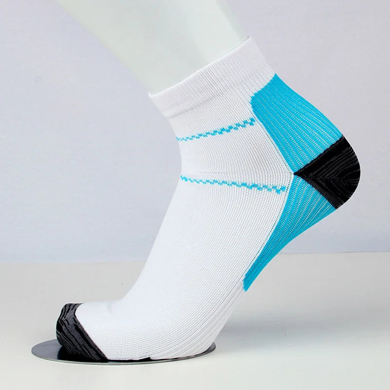 Chaussettes de compression blanches avec des accents bleus et noirs sur une jambe modèle blanche.