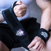 Une personne applique un bracelet de gym noir avec un logo violet et blanc à son poignet pendant un entraînement de force.