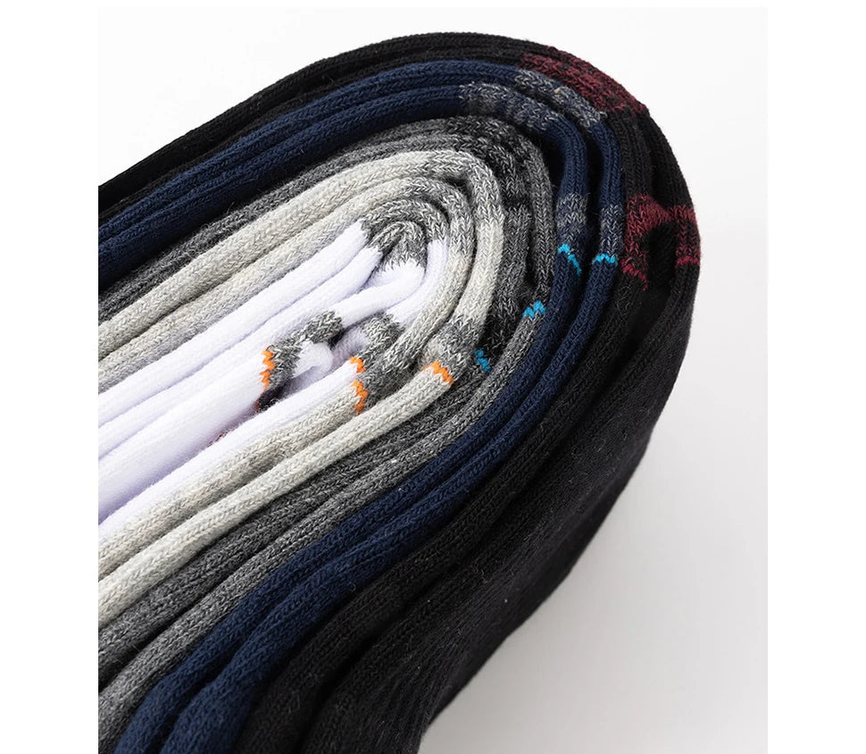 A stack of men's sport compression socks in various shades of gray, blue, and black.