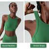 A green high-impact stretch yoga crop top worn by a model, showing the round neckline and stretch straps.