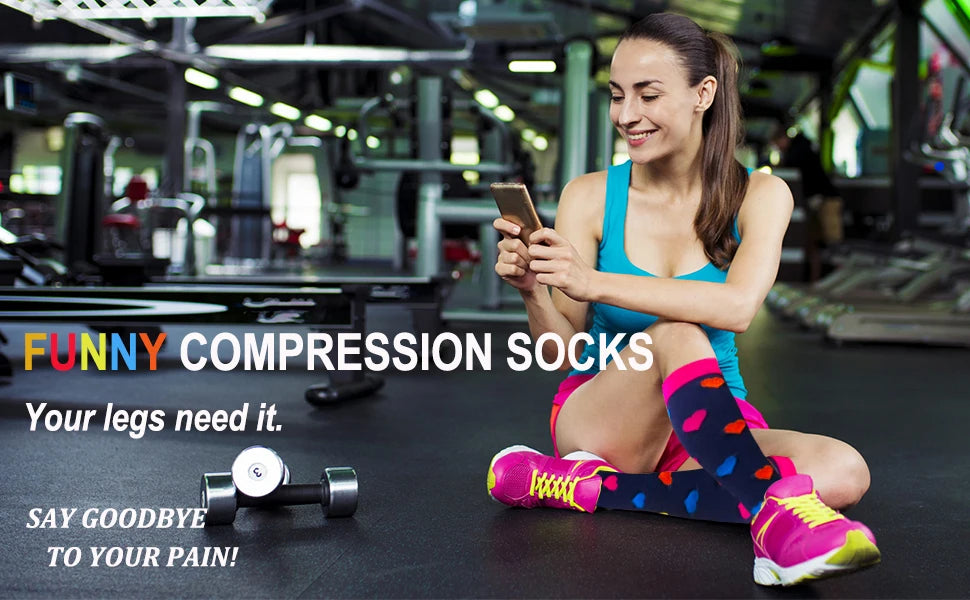 A woman is sitting on a gym floor smiling while holding a smartphone, promoting funny compression socks.