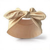 Un bandeau élastique beige noué en nœud, présenté sur fond blanc.