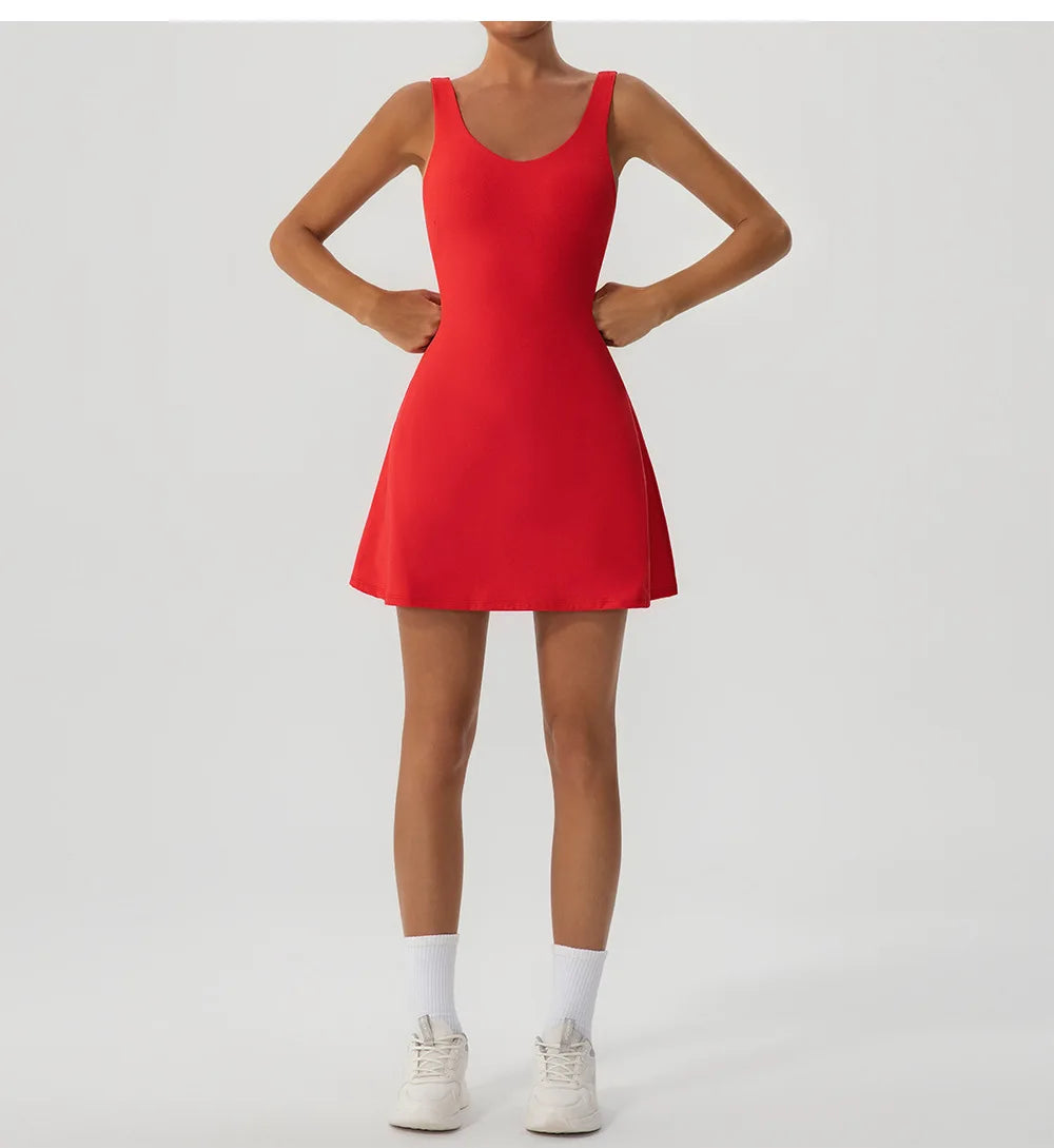 Un mannequin portant une robe de sport rouge deux pièces avec des chaussettes et des baskets blanches.