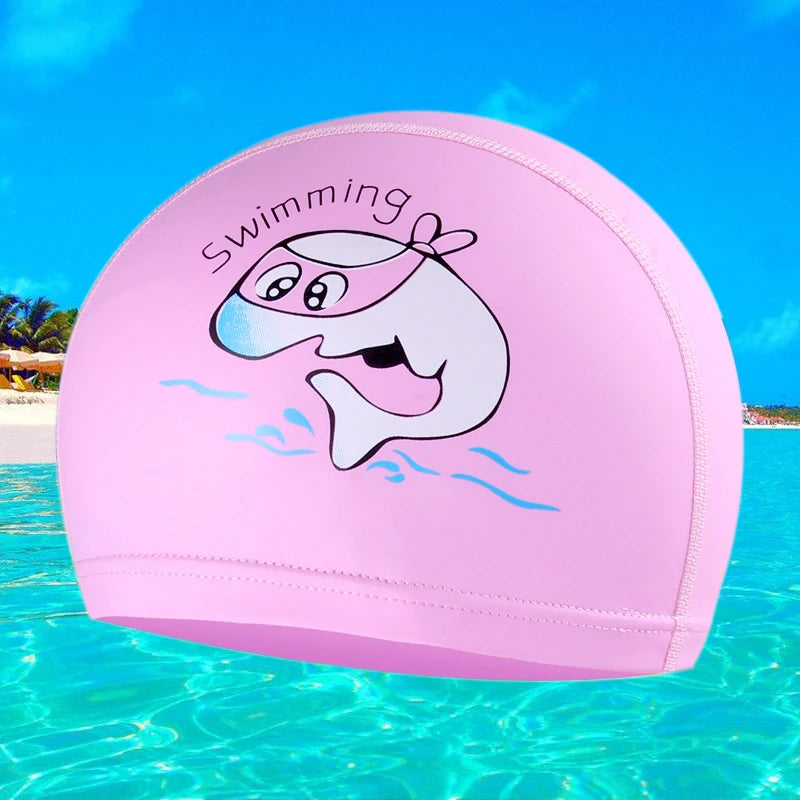 A pink cartoon swimming cap featuring a smiling whale splashing water in clear blue ocean water.