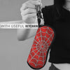 A red spider web patterned eyeglass pouch attached to a keychain, held by a person.