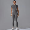 A model wearing a full-body, long-sleeved gray yoga jumpsuit with a high neck zipper.