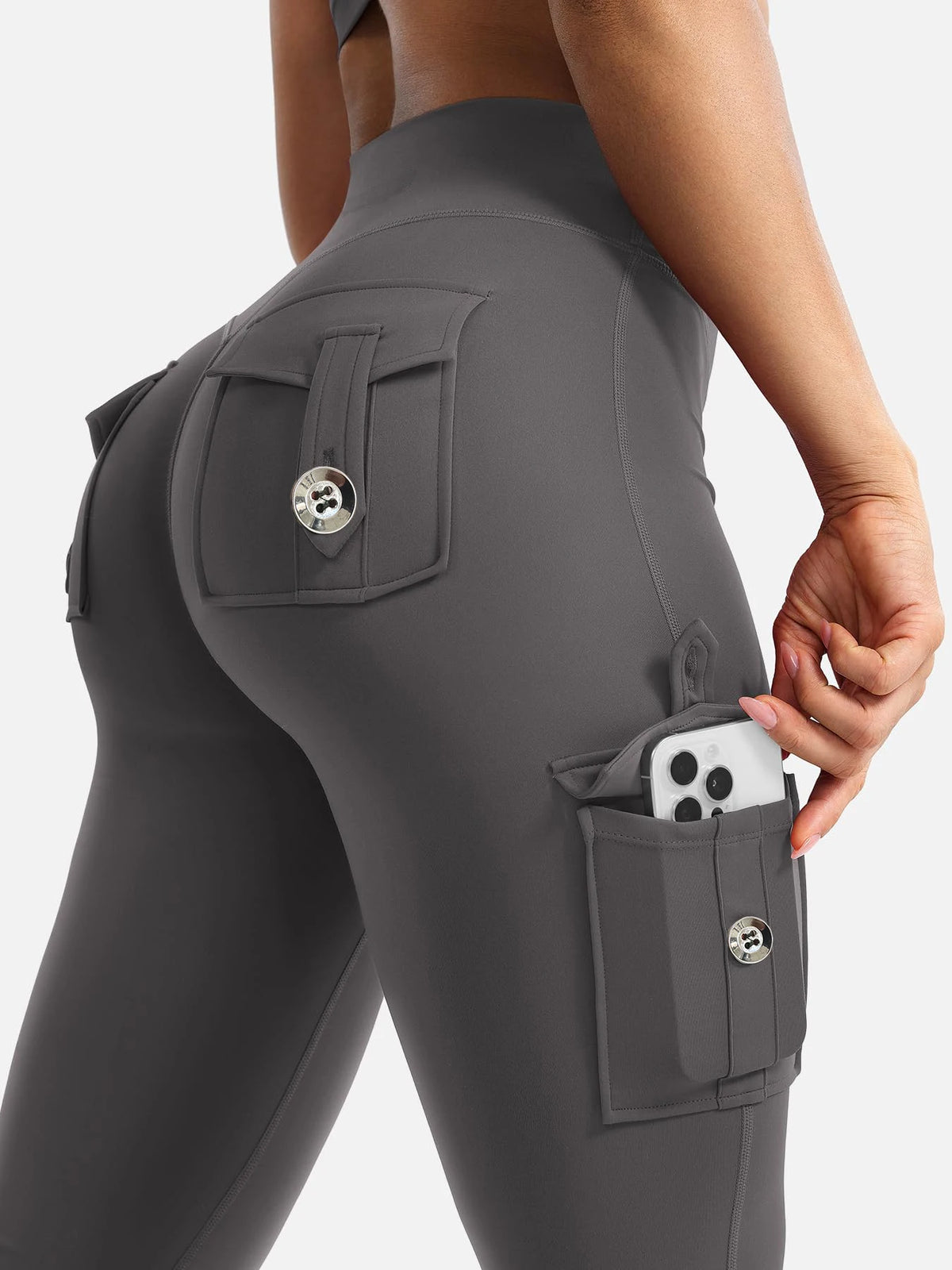 A close-up of a gray high-waisted flared fitness pant featuring multiple functional pockets.