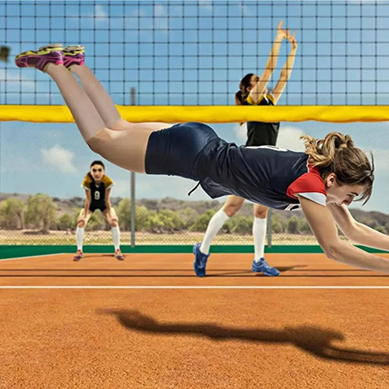 A female athlete performing a dive or stretch over a tennis net during outdoor practice.
