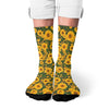 A pair of breathable crew socks featuring a vibrant yellow and green sunflower print.