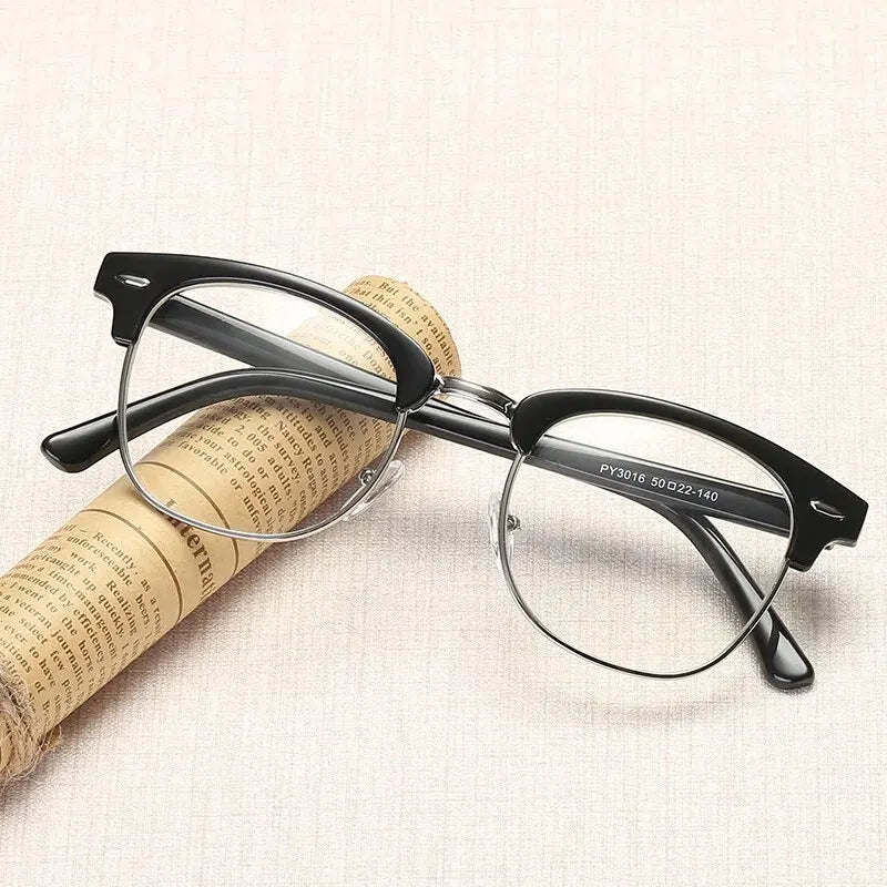 A pair of black-framed computer glasses rests on a piece of rolled-up paper.
