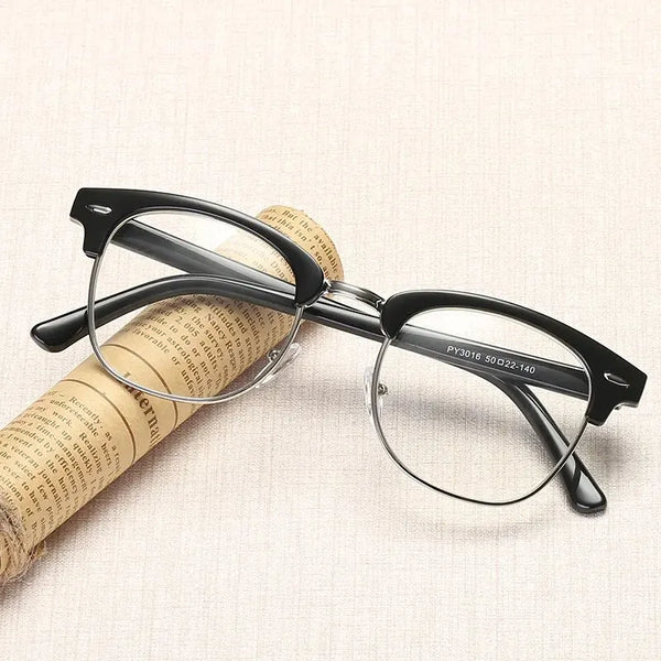 A pair of black-framed computer glasses rests on a piece of rolled-up paper.