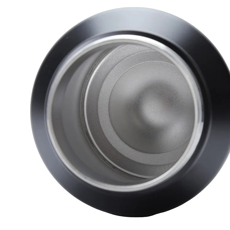 A close-up view of the silver interior and black exterior of an insulated stainless steel thermos flask.