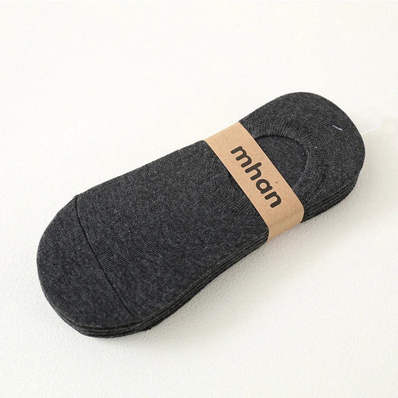 A dark gray ankle sock with a tan label featuring the brand name mhan.