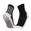 A pair of black and white performance sports grip socks shown from the side.