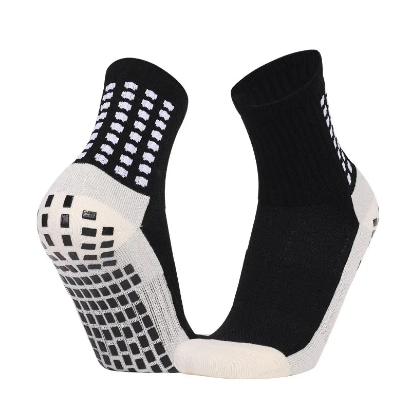 A pair of black and white performance sports grip socks shown from the side.