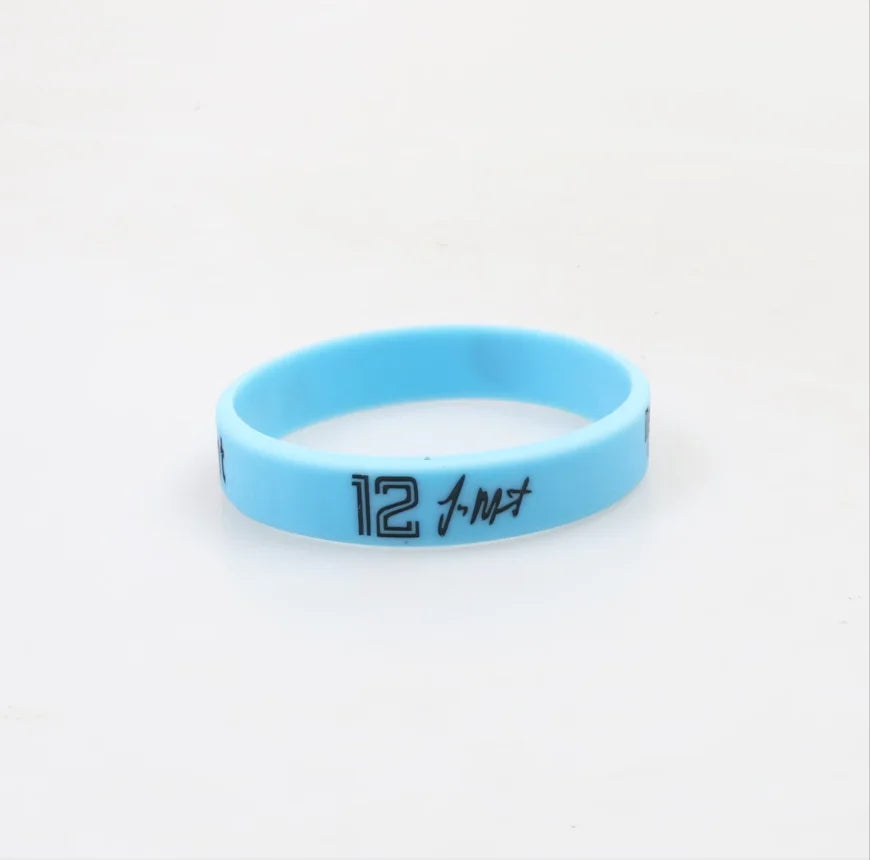 A light blue silicone wristband with the number 12 engraved on it.