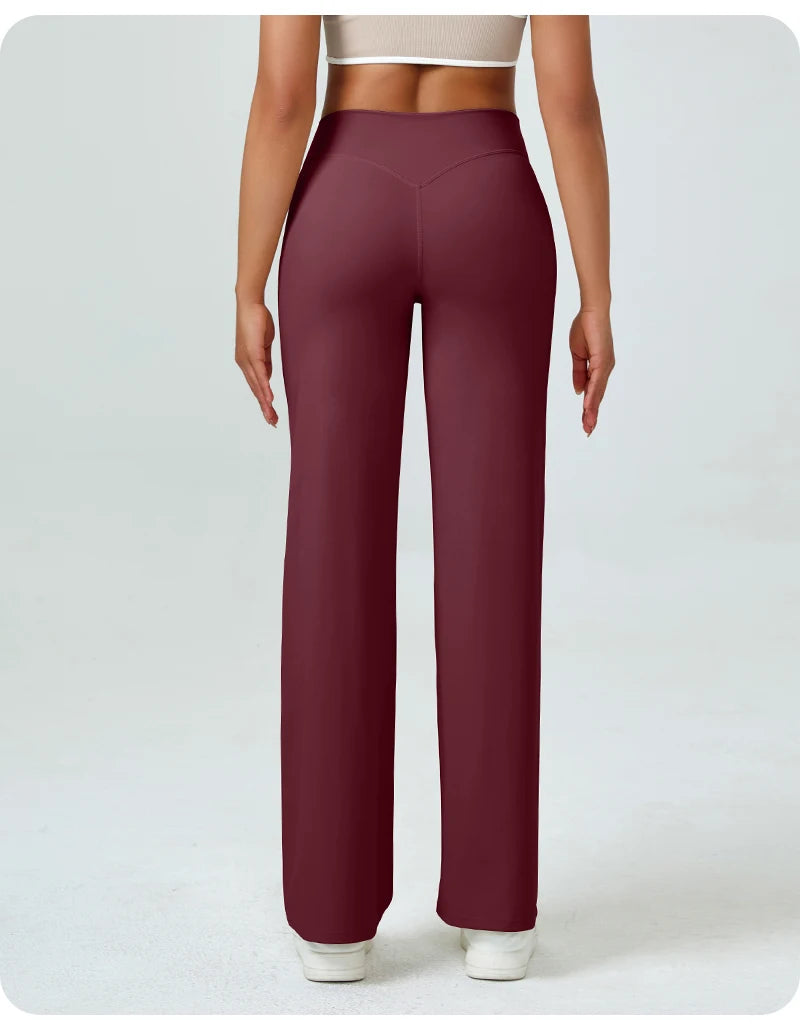 A woman wearing maroon high waisted yoga pants and a light top.