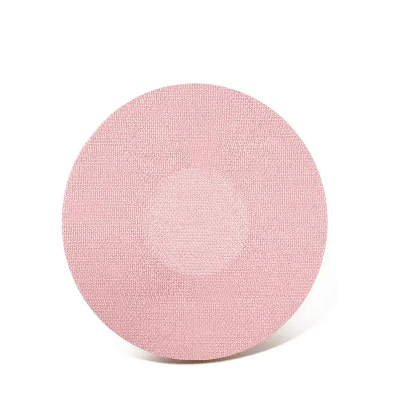 A round, light pink reusable adhesive patch for sensor fixing.