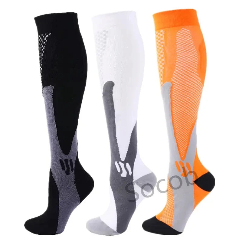 Three pairs of compression socks in black, white, and orange for athletes and medical use