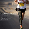A runner wearing black compression sleeves on his legs while jogging outdoors.