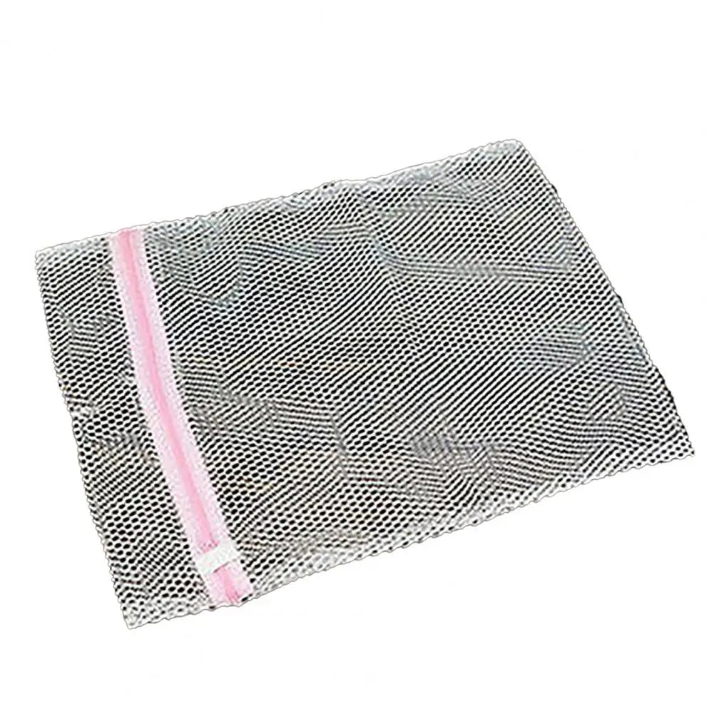 Bolsa organizadora de ropa de malla clara con ribete rosa, vista desde arriba.