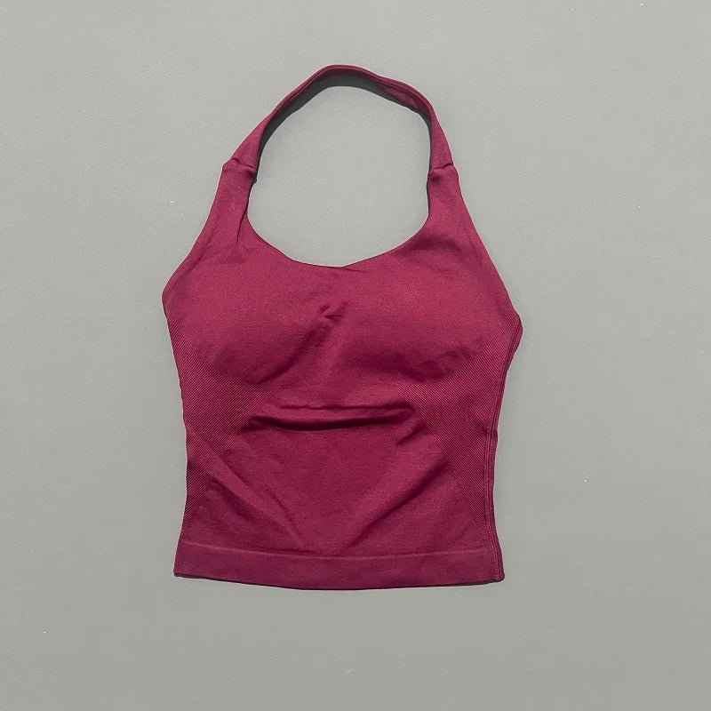 A solid magenta seamless performance yoga and gym tank top displayed against a light gray background.