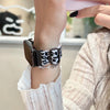 A close-up of a leopard print silicone watch band being worn on a wrist.