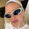 Close-up of a woman wearing silver-framed vintage rectangle aviator sunglasses and a white top.