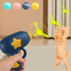 Une main tient un jouet disque volant interactif bleu et jaune, avec un chat qui saute en arrière-plan.