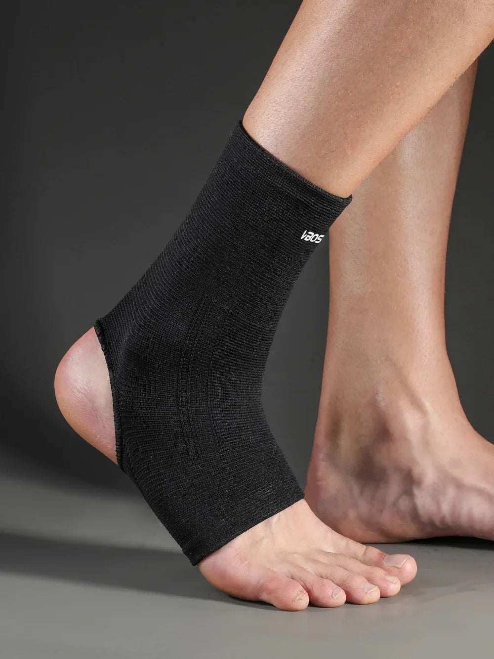 A close-up of a black ankle support brace worn on a person's lower leg.