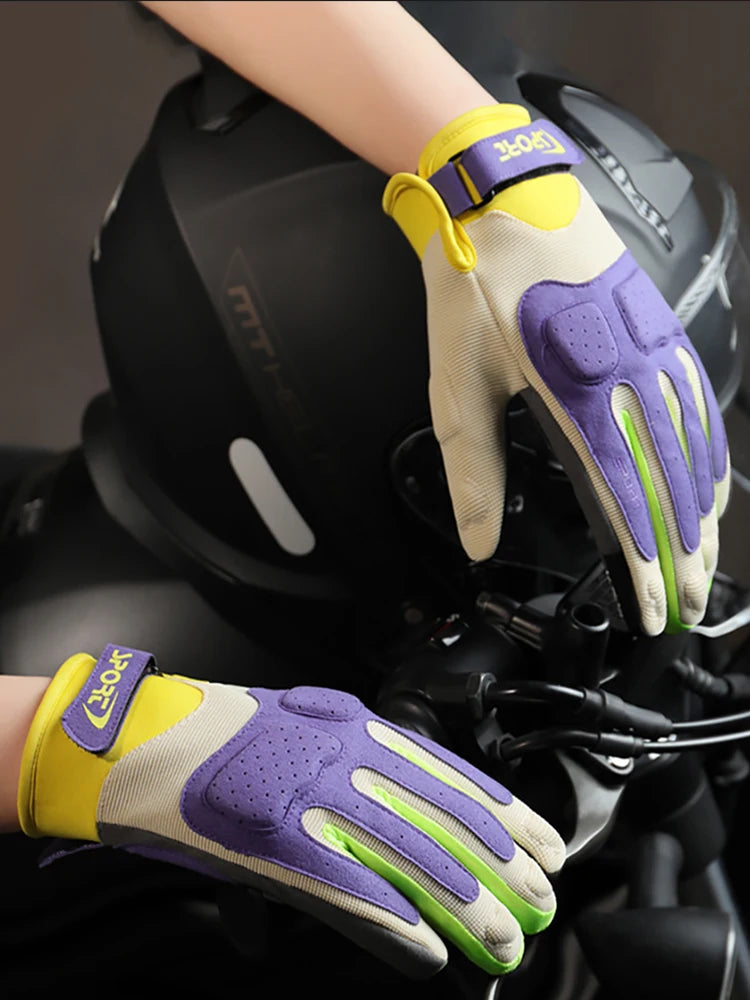 A close-up of yellow and purple breathable motorcycle riding gloves being worn on a hand.