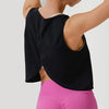Eine Frau trägt ein schwarzes, nahtloses Crop-Top und leuchtpinke Leggings.