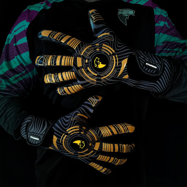 A close-up of a hand wearing black and gold goalkeeper gloves with a green and purple striped shirt.