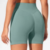 Un mannequin portant des shorts de yoga sans couture taille haute vert sauge clair pour la salle de sport et le fitness.