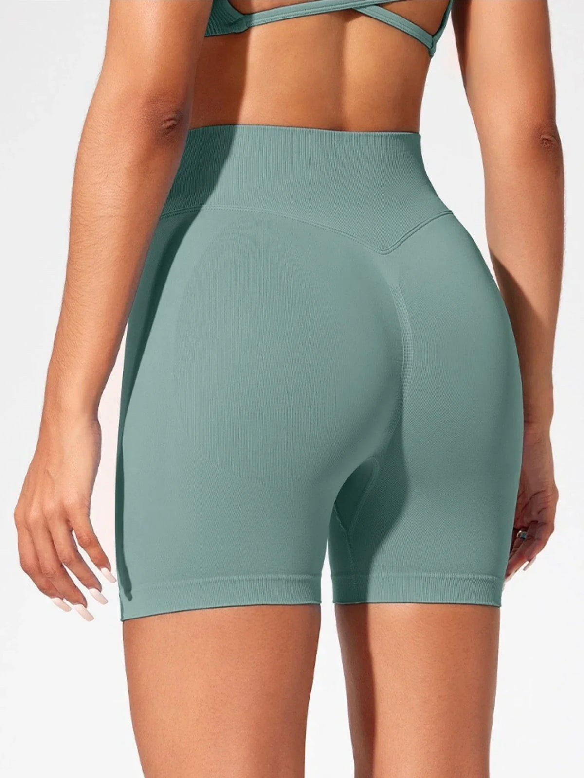 Un mannequin portant des shorts de yoga sans couture taille haute vert sauge clair pour la salle de sport et le fitness.