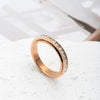 A close-up shot of a gold-toned statement ring with CZ gemstones on a white surface.