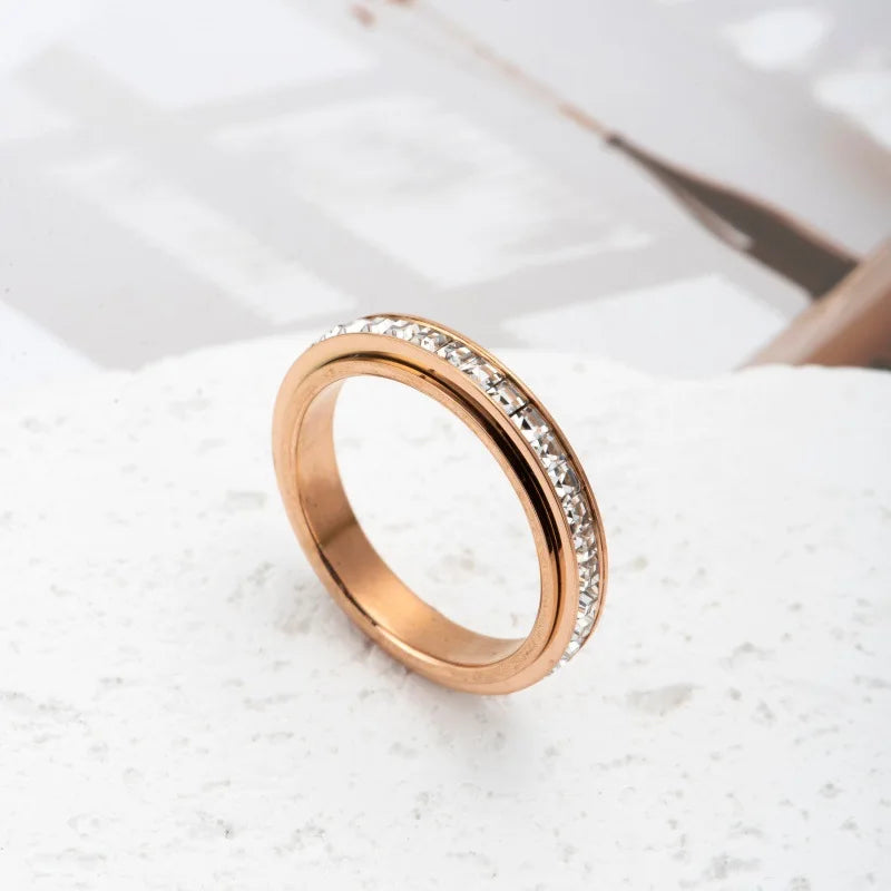 A close-up shot of a gold-toned statement ring with CZ gemstones on a white surface.