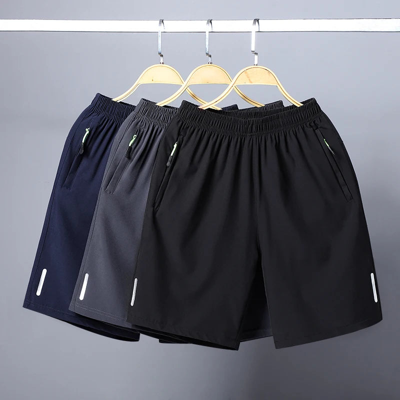 Black and navy men's quick dry jogging shorts hanging on a rack