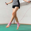 A person is exercising while using a pink resistance band ankle support compression brace on their foot.