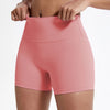 Gros plan d'une femme portant des shorts de yoga et de sport corail rose taille haute.