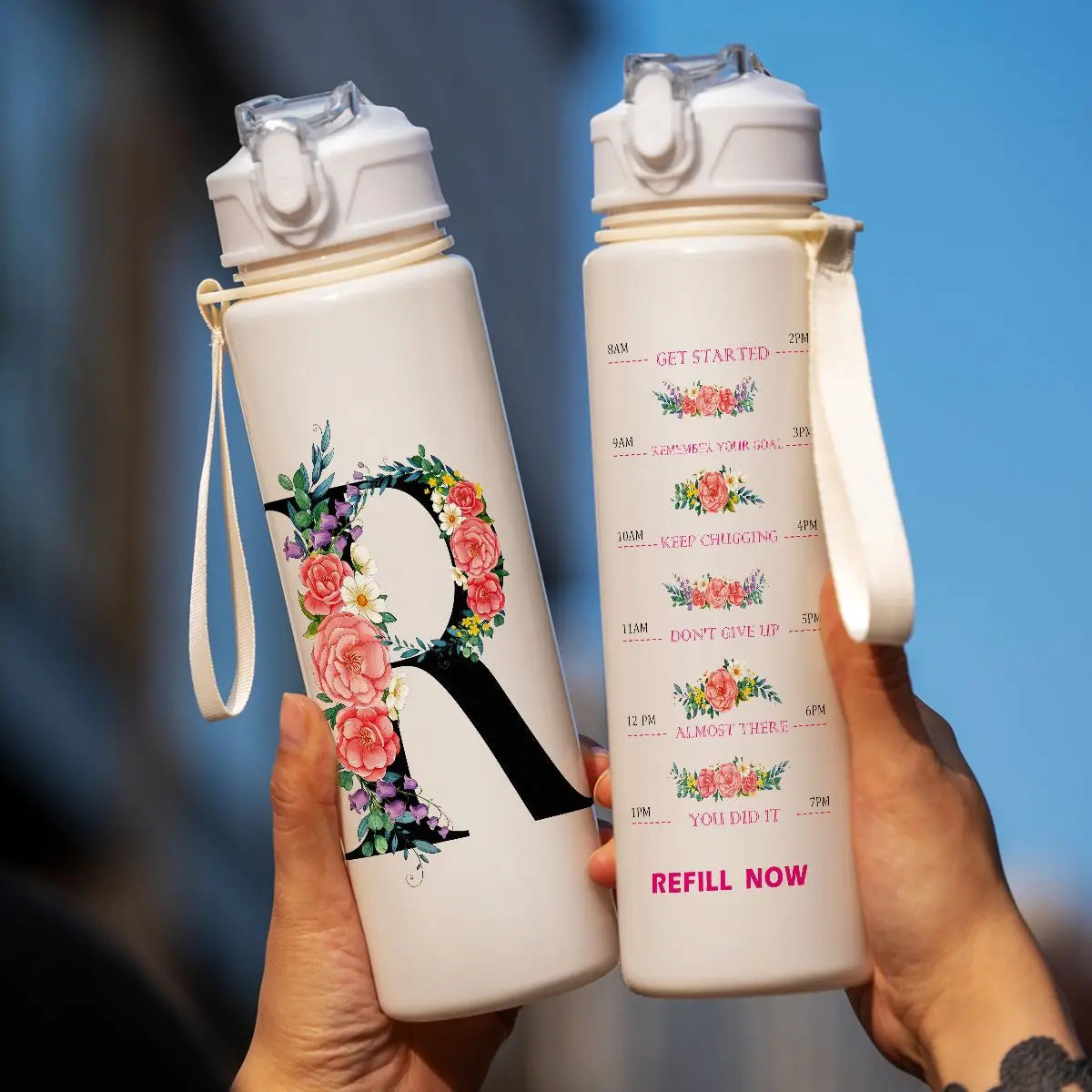 A person holds a white insulated straw tumbler with a large letter R design, ready to refill.