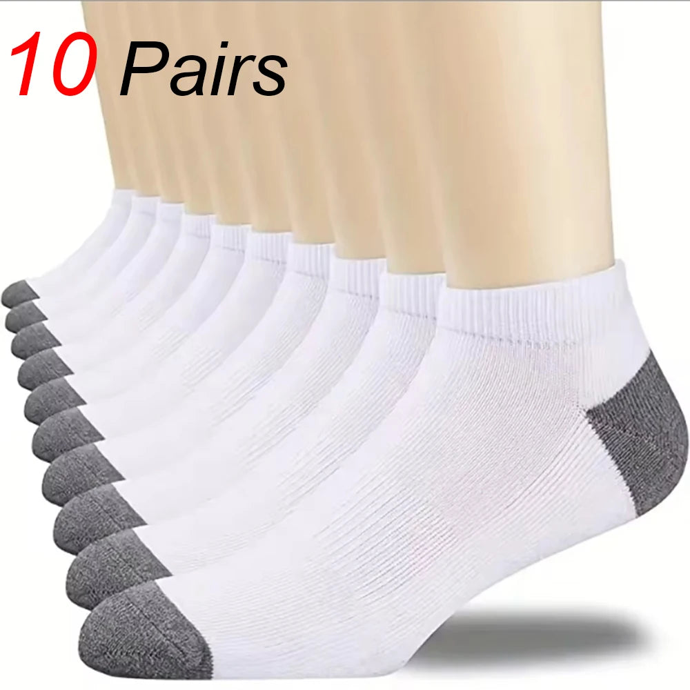A stack of ten pairs of white and gray ankle socks displayed on a person's leg.
