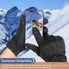 Black thermal windproof outdoor gloves holding a smartphone with a touchscreen device in a snowy mountain landscape