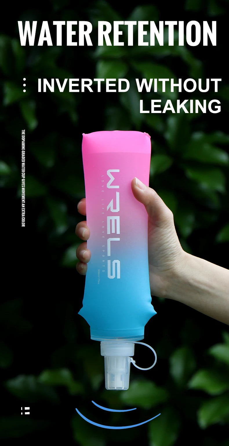 A hand holds a pink and blue inverted water bottle against a dark green, leafy background.