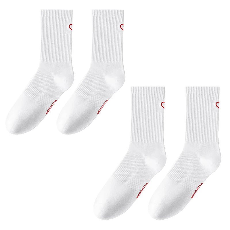 A set of white crew socks with red trim and ribbed texture displayed against a white background.