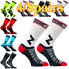 A collection of four pairs and eight pairs of black and white compression cycling socks.
