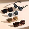 A collection of vintage cat eye sunglasses in black, brown, and gold gradient lenses displayed on a light background.