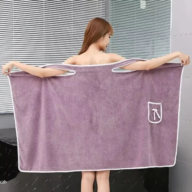 A woman wearing a purple soft fleece bath robe, displayed against a modern window backdrop.