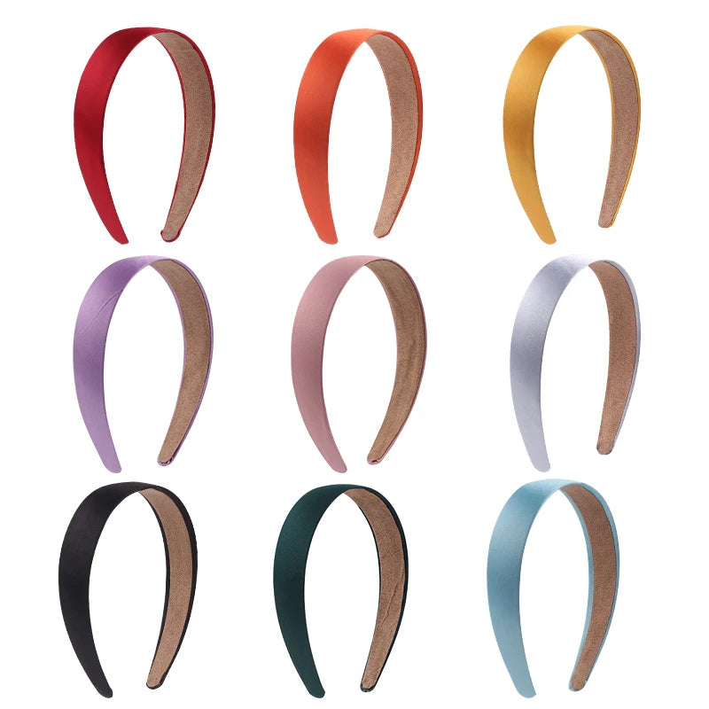 A collection of nine solid satin hair bands in various colors including red, orange, gold, purple, pink, silver, black, and t