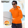 Ein Mann mit orangefarbener, leichter Hoodie und Sonnenbrille steht am Ozean, mit UV-Schutzetikett sichtbar.